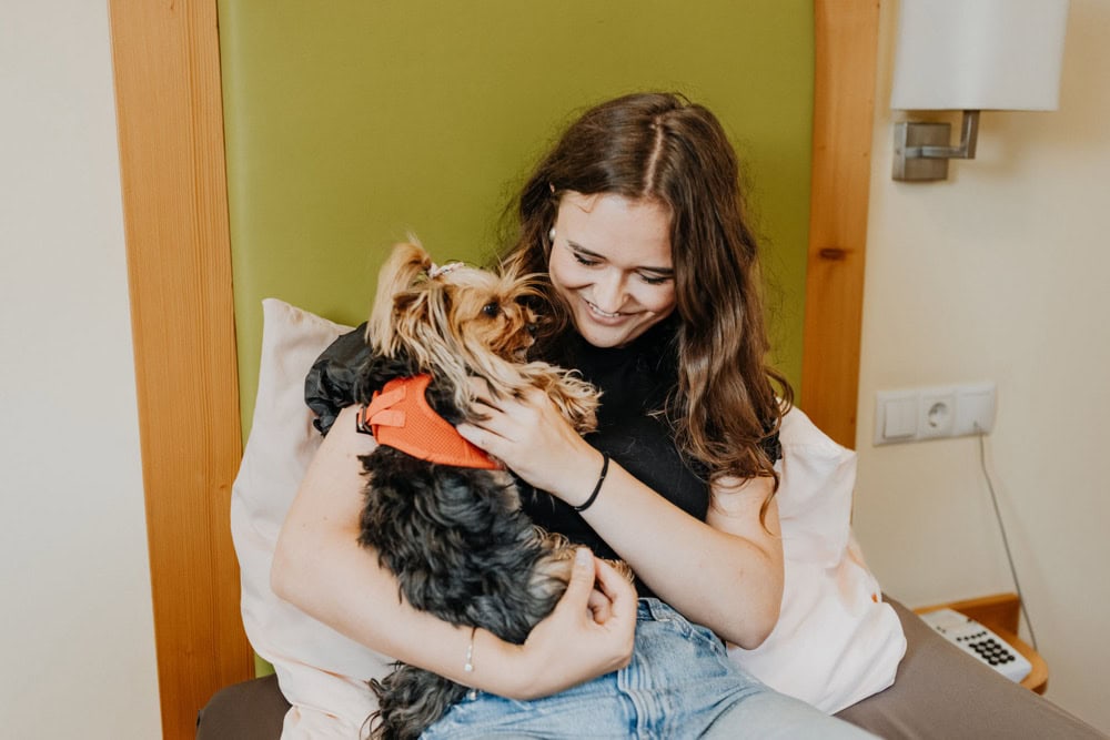 Woman with dog in hotel bed